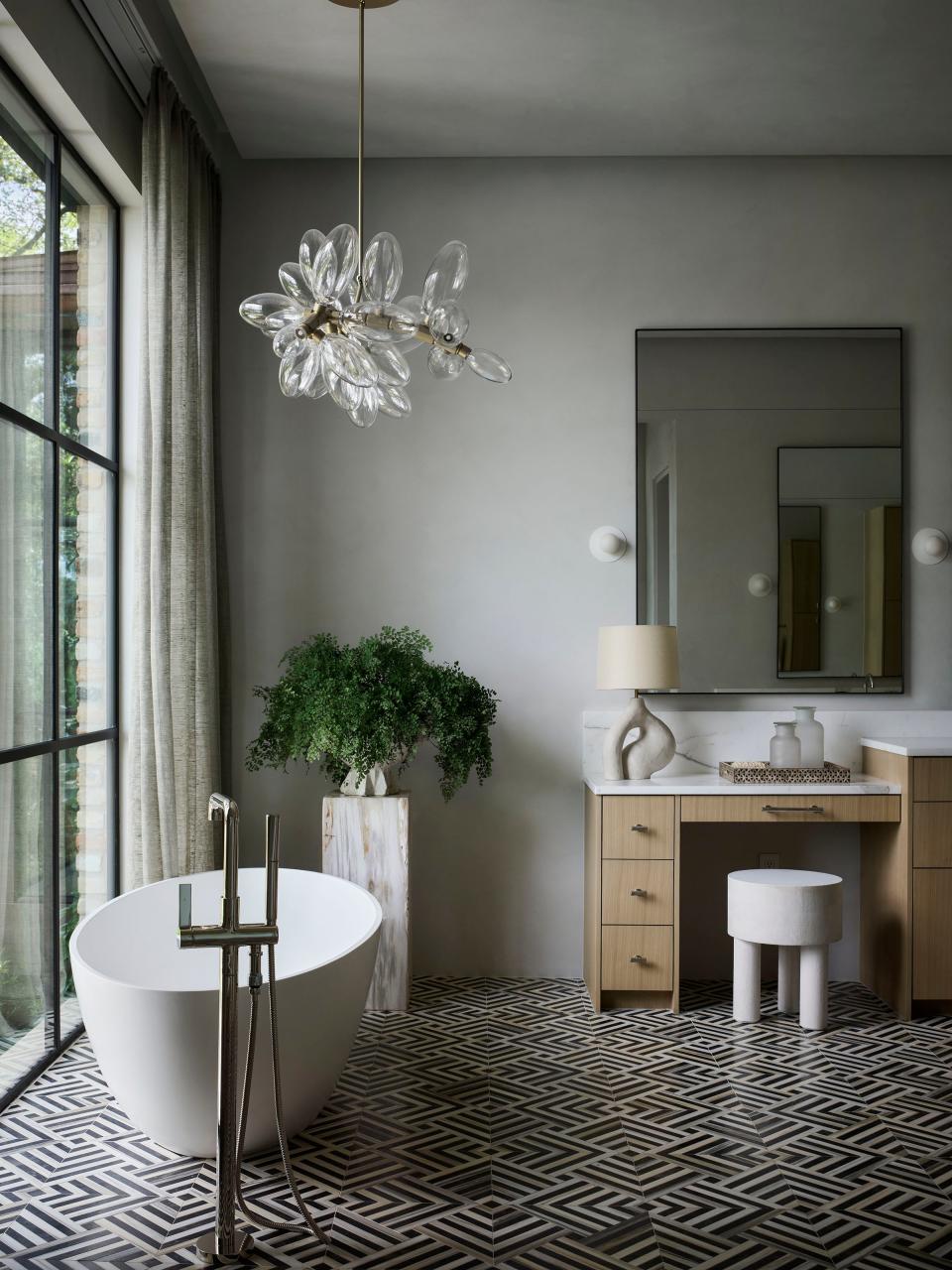 Black and white marble mosaics by Kelly Wearstler for Ann Sacks and a sculptural chandelier by Lindsey Adelman make the primary bath stand out.