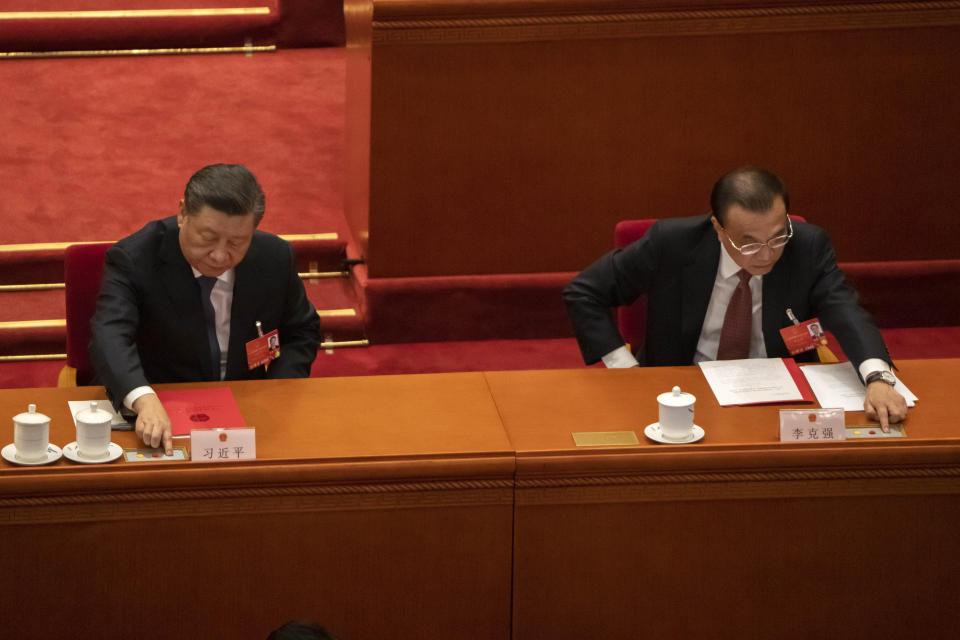 Chinese President Xi Jinping, left, and Premier Li Keqiang vote during the closing session of China's National People's Congress (NPC) at the Great Hall of the People in Beijing, Friday, March 11, 2022. (AP Photo/Sam McNeil)