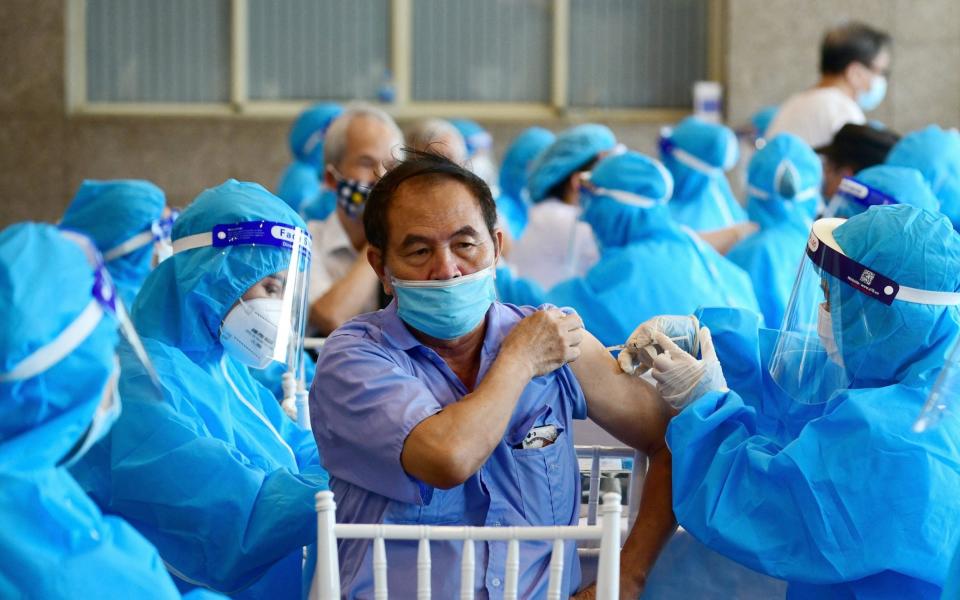  A man receives the AstraZeneca vaccine in Hanoi - AFP