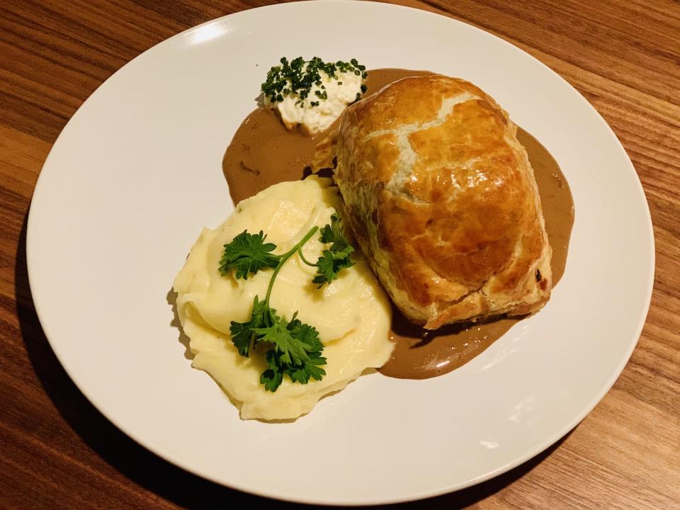 Beef Wellington plated with creme on white plate