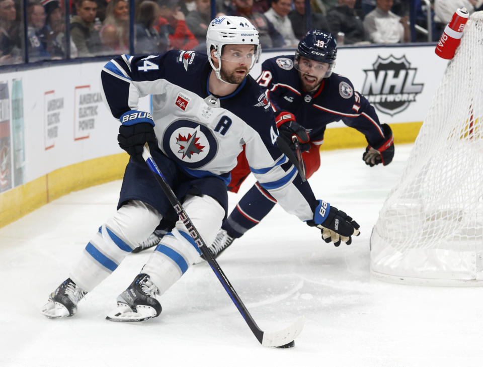 Winnipeg Jets defenseman Josh Morrissey, left, controls the puck in front of Columbus Blue Jackets forward Liam Foudy during the second period of an NHL hockey game in Columbus, Ohio, Thursday, Feb. 16, 2023. (AP Photo/Paul Vernon)