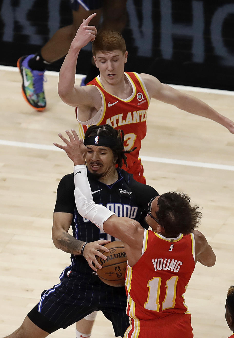 Orlando Magic guard Cole Anthony, center, drives the ball against Atlanta Hawks' Trae Young, right, in the first half of an NBA basketball game Tuesday, April 20, 2021, in Atlanta. (AP Photo/Ben Margot)