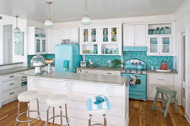 <p>RICHARD LEO JOHNSON</p> Aqua hues, including vibrant retro furniture, ground this contemporary kitchen in 1950s style.