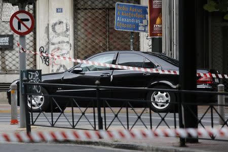 The car of former Greek prime minister and former central bank chief Lucas Papademos is secured by police following the detonation of an envelope injuring him and his driver, in Athens, Greece, May 25, 2017.