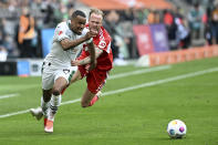 Moenchengladbach's Alassane Plea, left, and Berlin's Kevin Vogt, right, challenge for the ball during German Bundesliga soccer match between Borussia Moenchengladbach and 1. FC Union Berlin in Moenchengladbach, Germany, Sunday, April 28, 2024. (Federico Gambarini/dpa via AP)