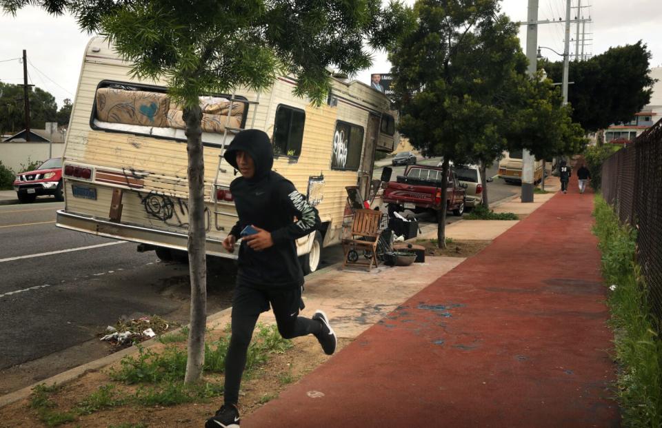 A runner passing an RV parked near a sidewalk