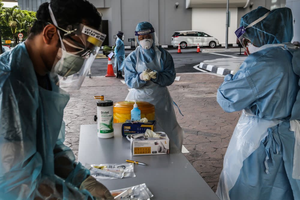 Health workers suit up at a drive-through testing site for Covid-19 at KPJ Ampang Puteri, April 6, 2020. — Picture by Firdaus Latif