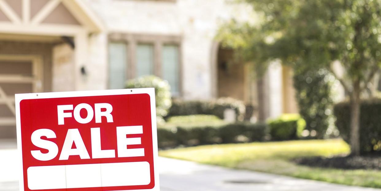 house for sale with real estate sign in yard