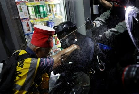 An anti-government protester is pepper-sprayed during a clash with the police near Yuen Long station, in Hong Kong