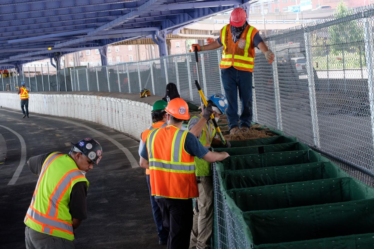 Workers construct temporary flood barriers near the South Street Seaport in Lower Manhattan, New York on Sunday, August 2, 2020. 