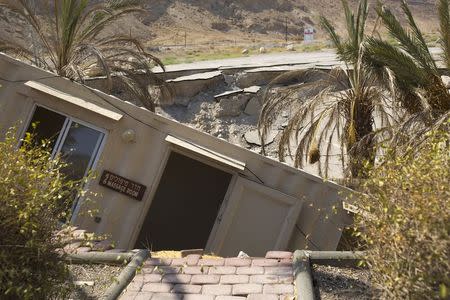 A structure that collapsed into a sinkhole is seen at an abandoned tourist resort on the shore of the Dead Sea, Israel July 28, 2015. REUTERS/Amir Cohen