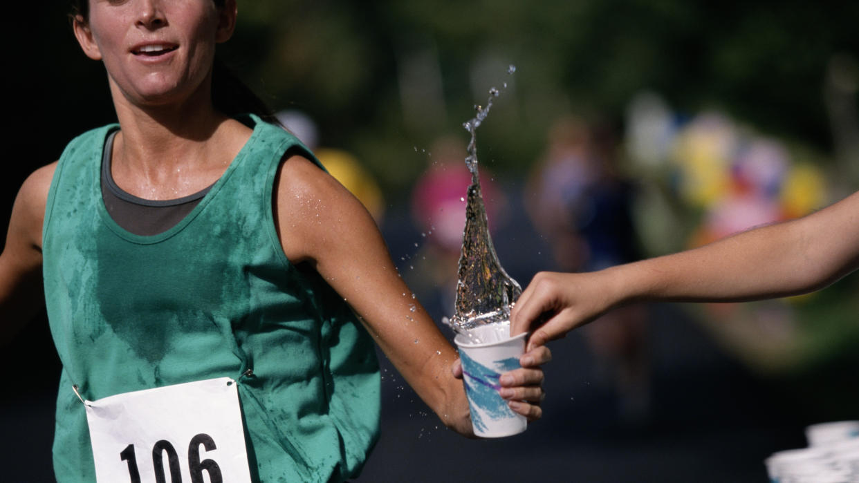  Runner taking cup of water during race. 