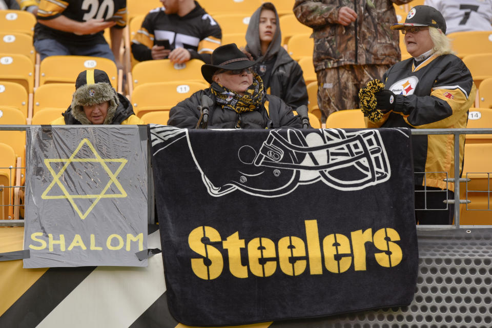 Pittsburgh Steelers fans sit behind a banner with a Star of David beside their Steelers blanket as they watch the teams warm up before an NFL football game between the Steelers and the Cleveland Browns, Sunday, Oct. 28, 2018, in Pittsburgh. There was a deadly shooting in a Pittsburgh synagogue on Saturday. (AP Photo/Don Wright)