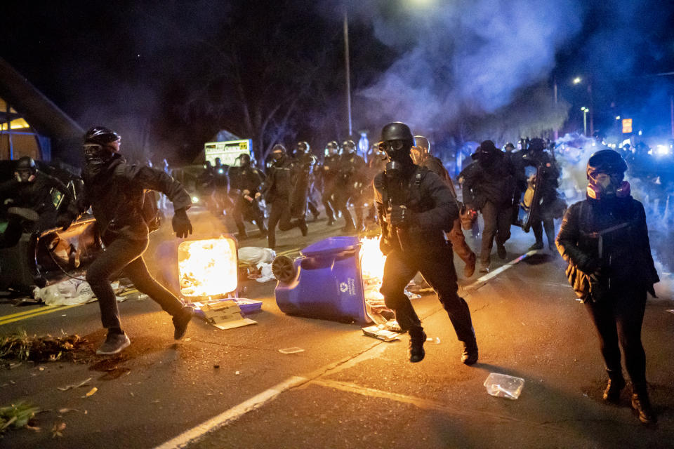 Portland police officers chase protesters during a riot in the wake of Daunte Wright's death.