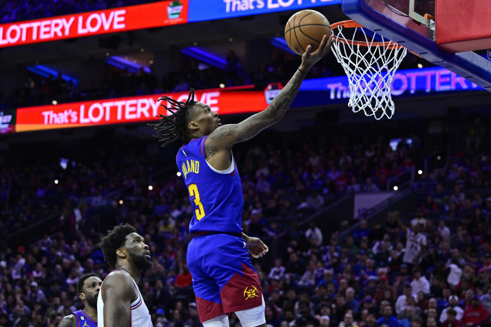 Denver Nuggets' Bones Hyland (3) scores a basket past the defense of Philadelphia 76ers' Joel Embiid during the first half of an NBA basketball game, Saturday, Jan. 28, 2023, in Philadelphia. (AP Photo/Derik Hamilton)