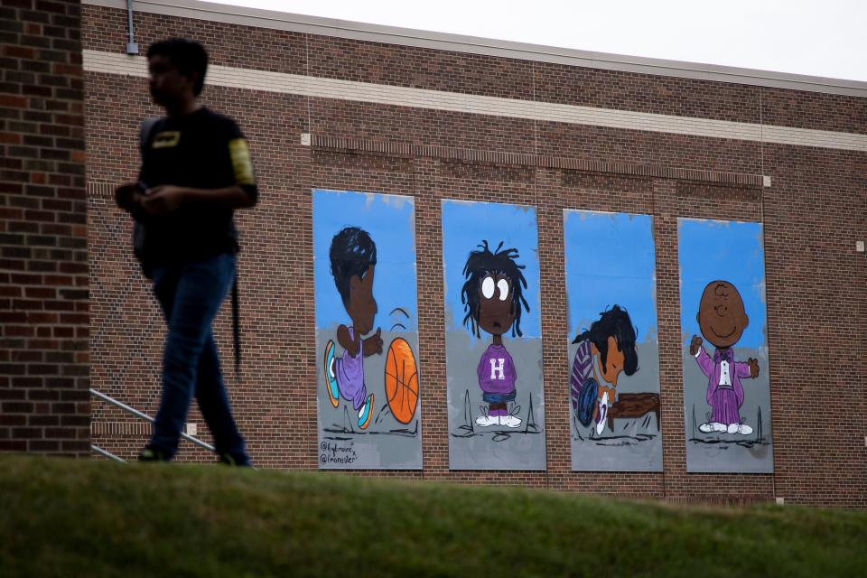 Harding Elementary School students walk past a then-new mural by Robert Moore on the side of the school in 2021.