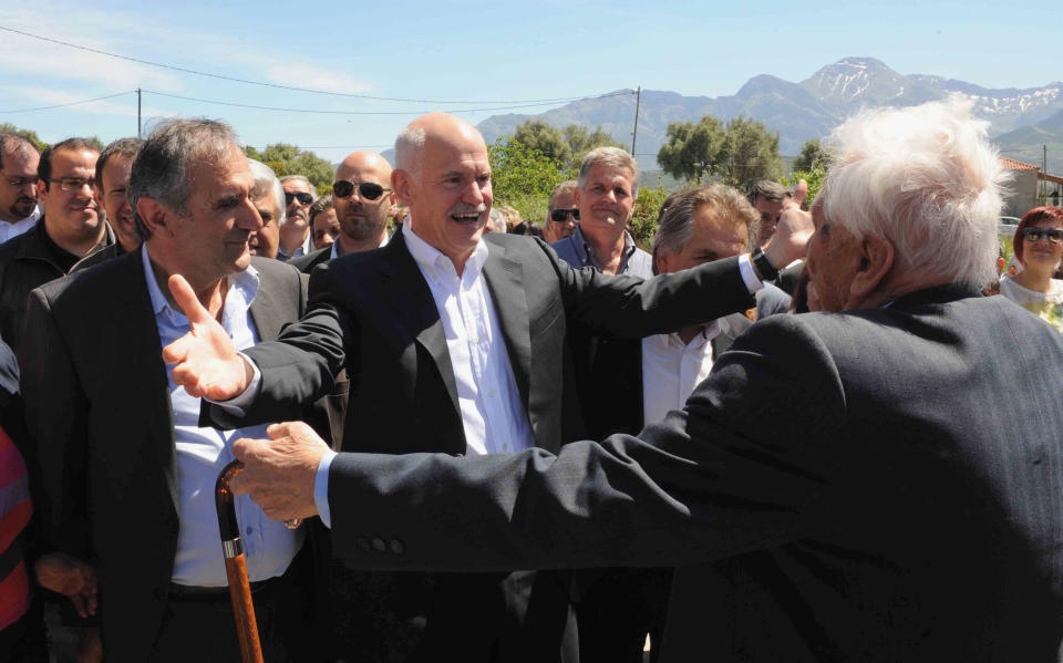 Former Socialist Prime Minister George Papandreou, 2nd left, is welcomed by supporters prior to casting his ballot in Kalentzi, western Greece Sunday May 6, 2012. Greeks head to the polls Sunday in their most critical and uncertain election in decades, with voters set to punish the two main parties that are being held responsible for the country's dire economic straits. (AP Photo/Yannis Androutsopoulos)