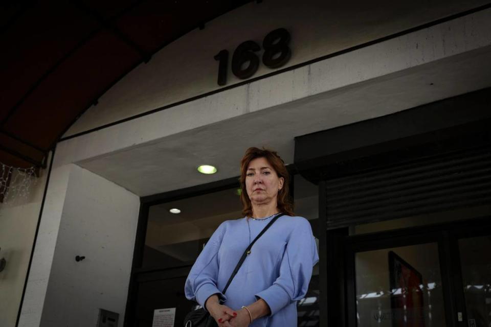 Diliana Alexander, tenant on the fourth floor of the Huntington Building and executive director of FilmGate Miami, poses in front of the tower on Thursday, March 23, 2023, in downtown Miami after it was shut down by the city last week over a ‘life safety issue.’ ‘My mother put all of her retirement into this,’ Alexander said.