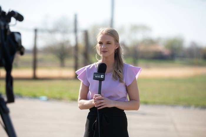 Reporter on field holding microphone for news segment