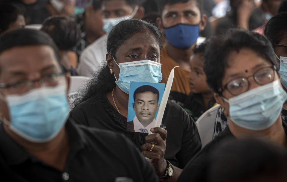 A Sri Lankan woman holds a portrait of her relative who died in 2019 Easter Sunday attacks during a service at St. Anthony's Church in Colombo, Sri Lanka, Wednesday, April 21, 2021. Wednesday marked the second anniversary of the serial blasts that killed 269 people. (AP Photo/Eranga Jayawardena)