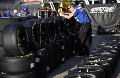 A technician checks tires during practice for the Auto Club 400. (USAT)