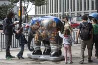 <p>Passer-by look on an elephant sculpture as part of the 'Elephant Parade' at the Paulista Avenue in Sao Paulo, Brazil, Aug. 1, 2017. (Photo: Sebastiao Moreira/EPA/REX/Shutterstock) </p>