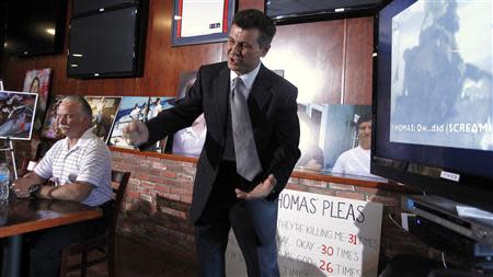 Garo Mardirossian, attorney for Ron Thomas (L), father of Kelly Thomas, swings his fist downwards as he describes the actions of police officers during their beating of Kelly Thomas, during a news conference in Los Angeles, California January 14, 2014. REUTERS/Alex Gallardo