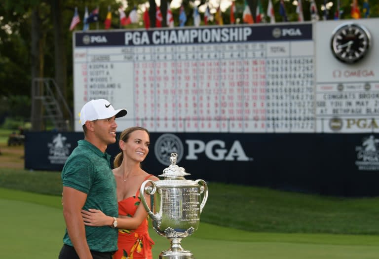 Brooks Koepka poses with his girlfriend, Jena Sims, and the Wanamaker Trophy on the 18th green after winning the 2018 PGA Championship