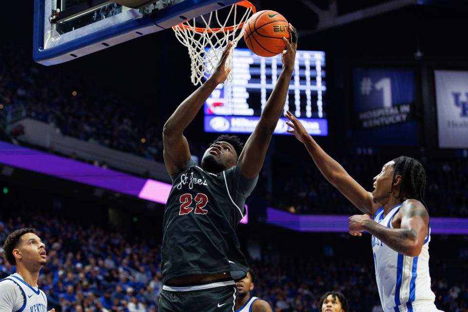 Christ Essandoko (22), a 7-foot center for the Saint Joseph's Hawks, drives to the basket during a game against Kentucky in November.  He will play at Providence in the fall.