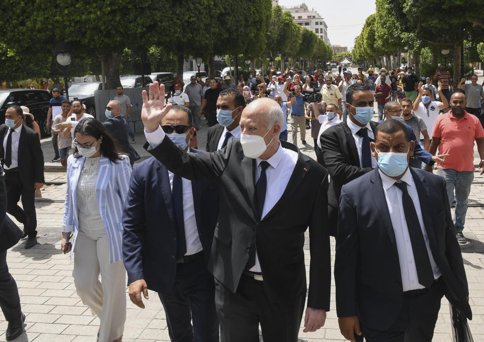 Tunisian President Kais Saied waves to bystanders as he stroll along the avenue Bourguiba in Tunis, Tunisia, Sunday, Aug. 1, 2021. President Kais Saied claimed on Sunday that some desperate youth are being paid to try to leave Tunisia illegally for Europe, saying the goal is to damage the country from within. (Slim Abid/Tunisian Presidency via AP)