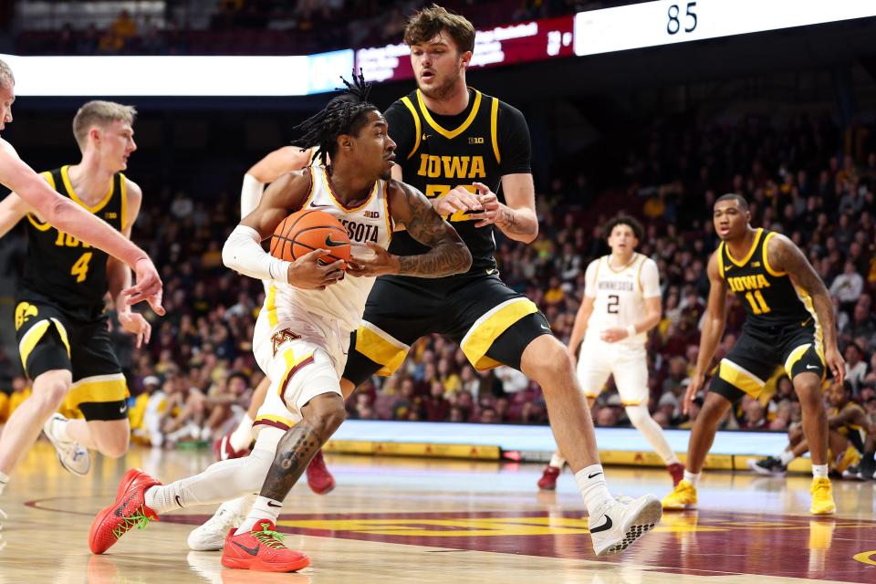 Jan 15, 2024; Minneapolis, Minnesota, USA; Minnesota Golden Gophers guard Elijah Hawkins (0) works towards the basket as Iowa Hawkeyes forward Owen Freeman (32) defends during the first half at Williams Arena. Mandatory Credit: Matt Krohn-USA TODAY Sports