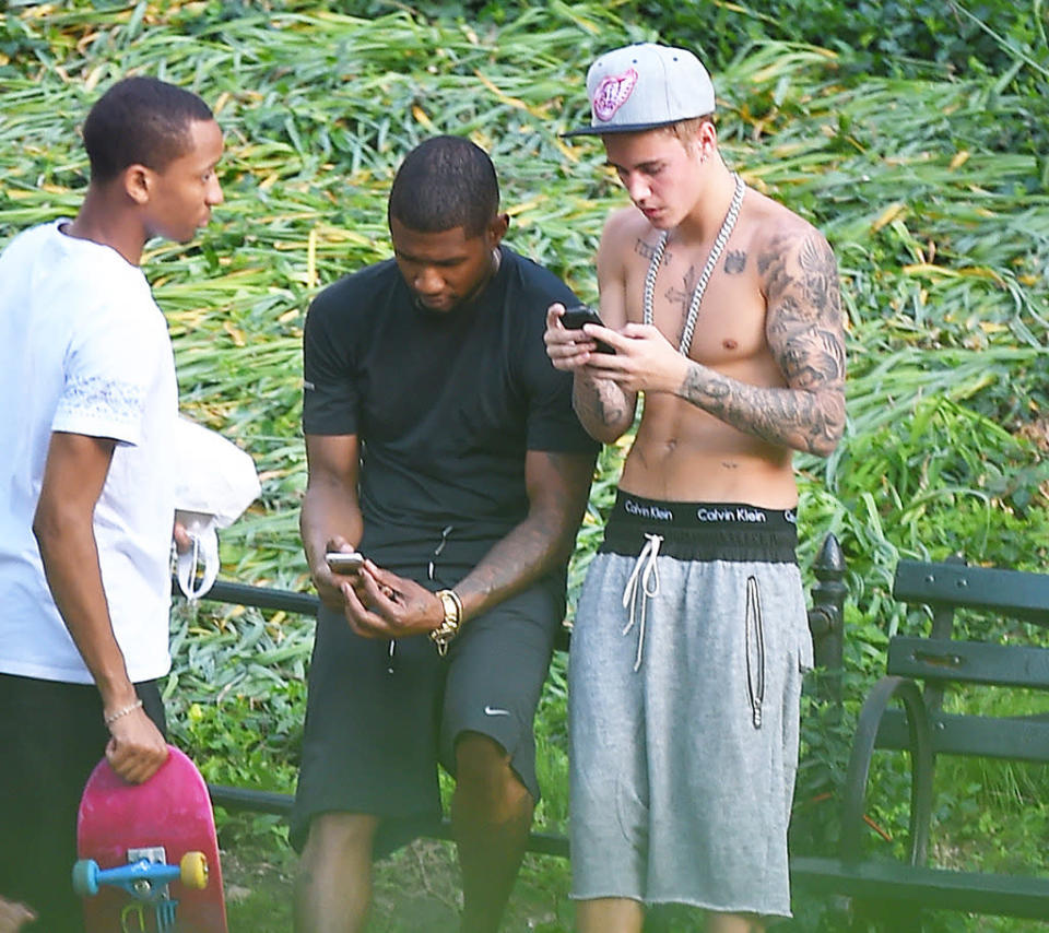 He doesn’t just do it at private parties. Here’s the Calvin Klein undies model, with Usher and friends, hanging out sans shirt in NYC’s Central Park. (Photo: Splash News)