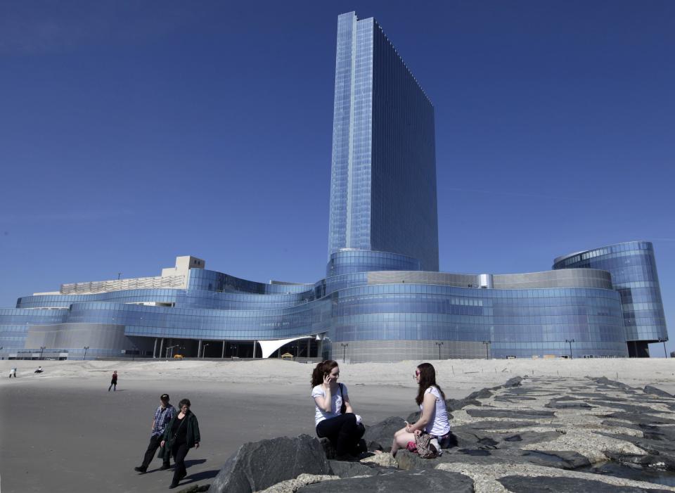 FILE - In this March 19, 2012 file photo, Kati MacFarline, left, of Nashua, N.H., and Christine Kashian, of Caribou, Maine, sit on a jetty near Revel in Atlantic City, N.J. Revel, the casino many people had hoped would turn around Atlantic City's sagging fortunes, said Tuesday, Feb. 19, 2013 that it will file for Chapter 11 bankruptcy protection in March, less than a year after it opened. (AP Photo/Mel Evans, File)