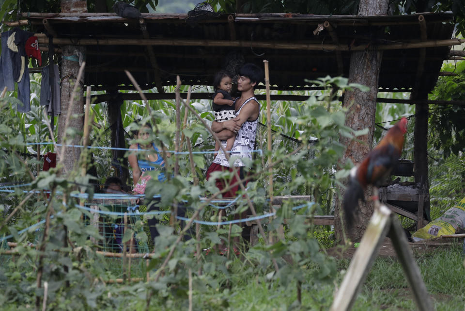 Ronnel Manjares, right, carries his daughter Crystal outside their house in Tanauan, Batangas province, Philippines, Wednesday, July 15, 2020. His 16-day-old son Kobe Christ Manjares was heralded as the country's youngest COVID-19 survivor. But the relief and joy proved didn't last. Three days later, Kobe died on June 4 from complications of Hirschsprung disease, a rare birth defect. (AP Photo/Aaron Favila)