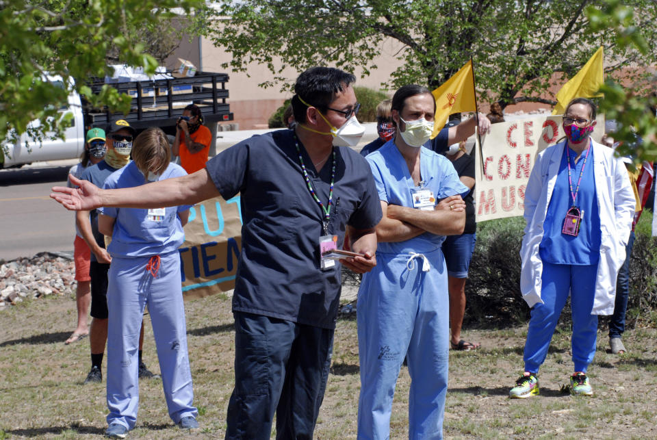 In this May 8, 2020, photo, medical staff from Rehoboth McKinley Christian Hospital including Caleb Lauber, center, hold a protest over working conditions and depleted staff in Gallup, N.M. Many nurses and doctors say staffing at the hospital was inadequate because of hospital CEO David Conejo's move to cut back on nurses in the first week of March to offset declining hospital revenues after elective surgeries were suspended. They voiced their discontent at the recent protest calling for his resignation. (AP Photo/Morgan Lee)