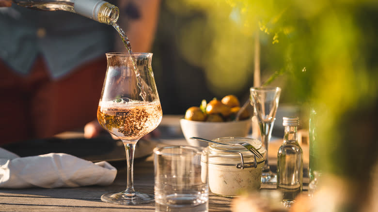 Man pouring rosé wine outside