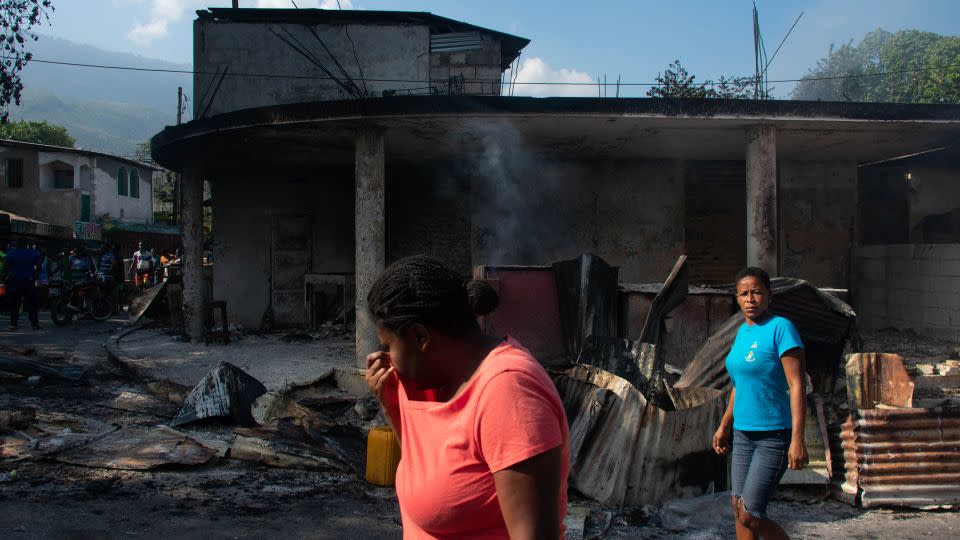 A woman cries as she walks near her husband's shop that armed gang members set fire to in Port-au-Prince, Haiti, March 7, 2024. Haiti's troubled capital is under a state of emergency as authorities struggle to rein in violent gangs demanding the prime minister resign. - Clarens Siffroy/AFP/Getty Images