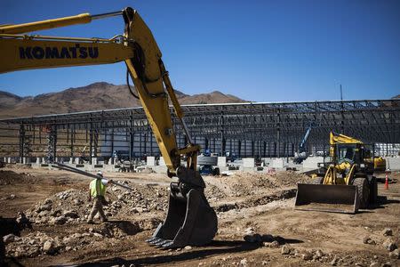 Electrician Darrell Scronce carries conduits at the construction site of a battery systems plant at the Tahoe-Reno Industrial Center in McCarran, Nevada, September 16, 2014. REUTERS/Max Whittaker