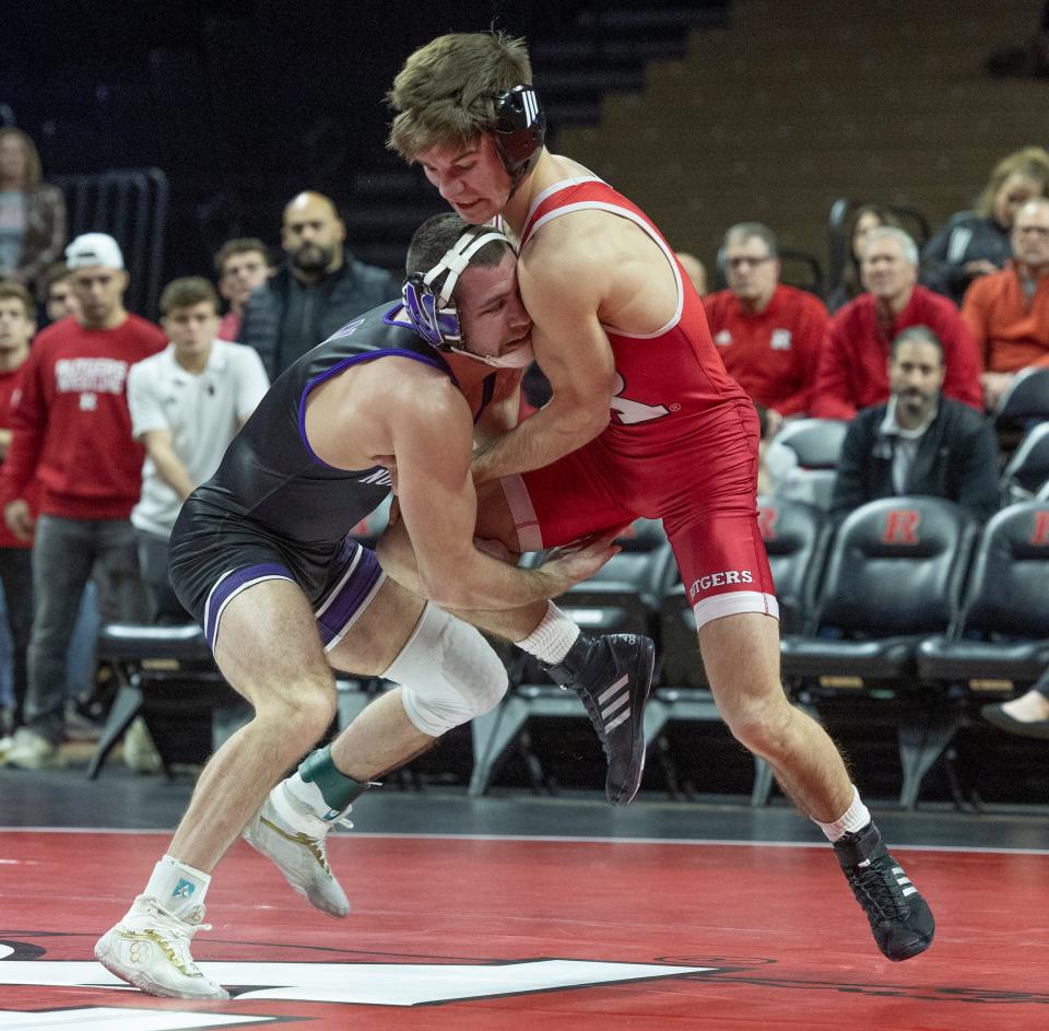 Northwestern's Chris Cannon (left) grabs the leg of Rutgers' Joe Heilmann in his 7-3 win in the 133-pound bout. Northwestern won the match 28-6.