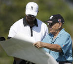 Golfer Tiger Woods, left, autographs a poster for marshall Frank Buterwaiser during the Pro-Am round of the Honda Classic golf tournament, Wednesday, Feb. 26, 2014 in Palm Beach Gardens, Fla. (AP Photo/Wilfredo Lee)