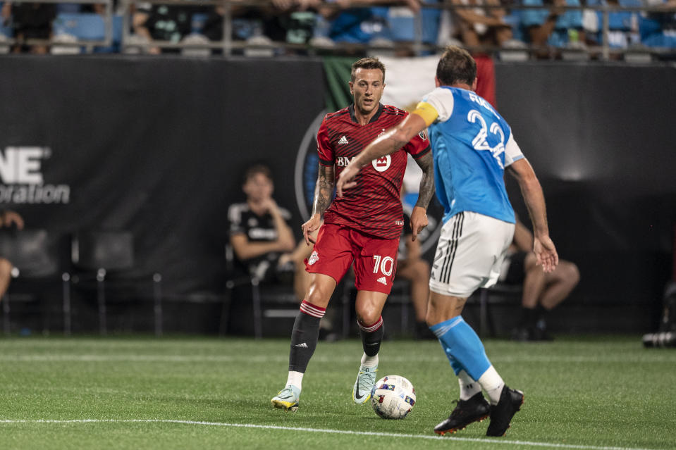 Toronto FC midfielder Alejandro Pozuelo (10) is denied by Charlotte FC defender Christian Fuchs (22) during the first half of an MLS soccer match, Saturday, Aug. 27, 2022, in Charlotte, N.C. (AP Photo/Matt Kelley)