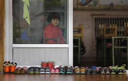 A girl sits on a chair in a class at a kindergarten, a school for children of migrant workers, on the outskirts of Beijing November 8, 2013. REUTERS/Jason Lee