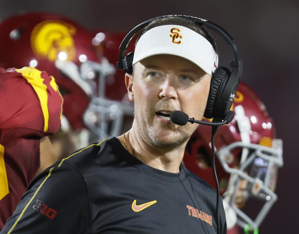 USC coach Lincoln Riley talks to staff via his headset during the team's win over Utah State Saturday at the Coliseum.