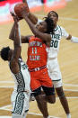 Illinois guard Ayo Dosunmu (11) shoots over the defense of Michigan State guard Rocket Watts (2) and forward Marcus Bingham Jr. (30) during the first half of an NCAA college basketball game, Tuesday, Feb. 23, 2021, in East Lansing, Mich. (AP Photo/Carlos Osorio)