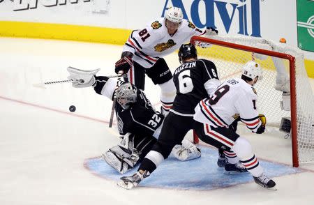May 24, 2014; Los Angeles, CA, USA; Los Angeles Kings goalie Jonathan Quick (32) makes a save as defenseman Jake Muzzin (6) tries to clear the puck away from Chicago Blackhawks players Marian Hossa (81) and Jonathan Toews (19) during the third period in game three of the Western Conference Final of the 2014 Stanley Cup Playoffs at Staples Center. Mandatory Credit: Richard Mackson-USA TODAY Sports