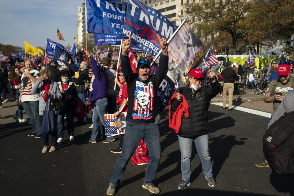 Supporters of President Donald Trump cheer as his motorcade drives past a rally of supporters near the White House, Saturday, Nov. 14, 2020, in Washington. (AP Photo/Evan Vucci)