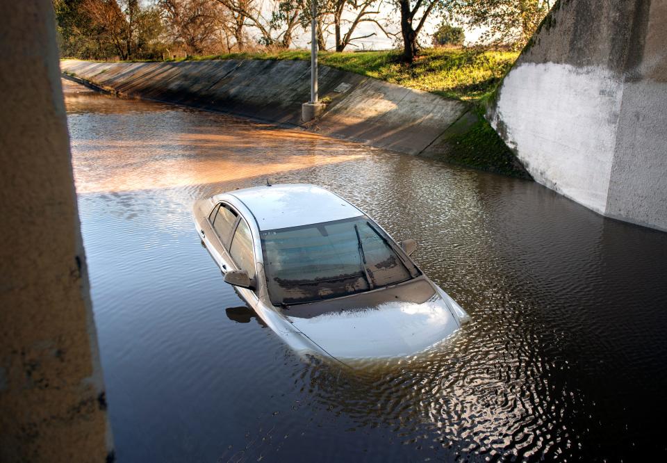 A stranded car was abandoned with flood waters up to its hood in the railroad subway underpass on Lower Sacramento Road between Acampo and Galt on Tuesday, Jan. 17, 2023. Heavy rains from storms left some streets flooded in the small unincorporated town north of Lodi.