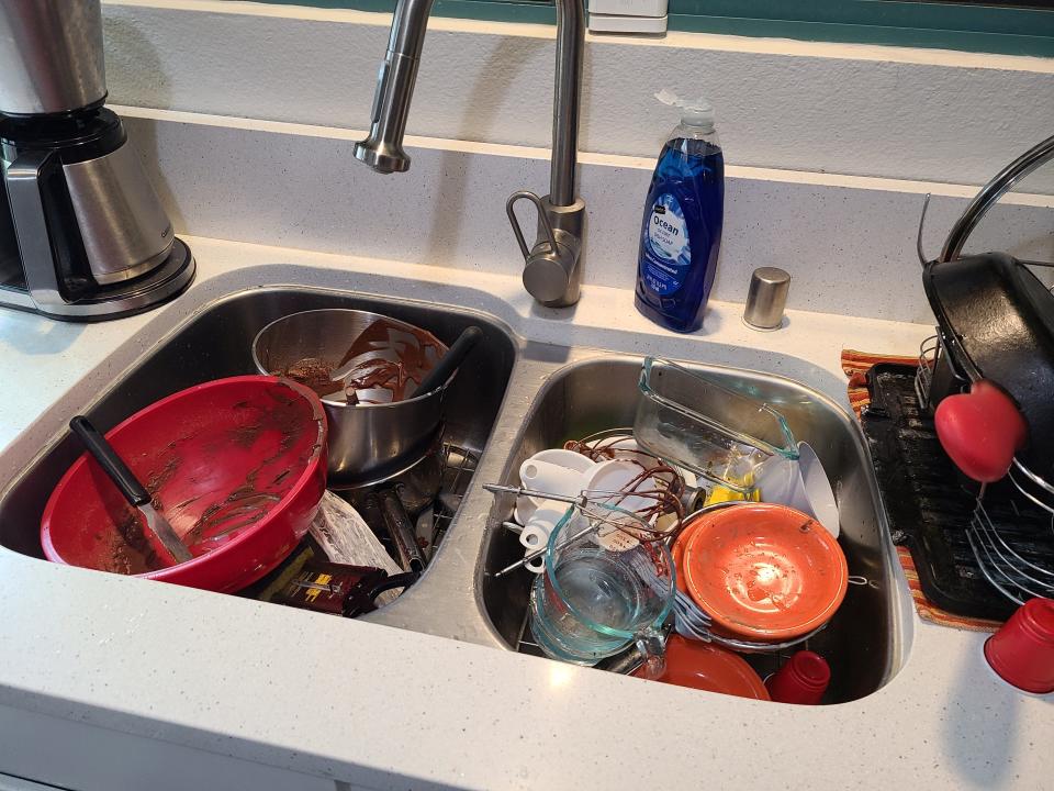 A messy kitchen sink full of dishes.