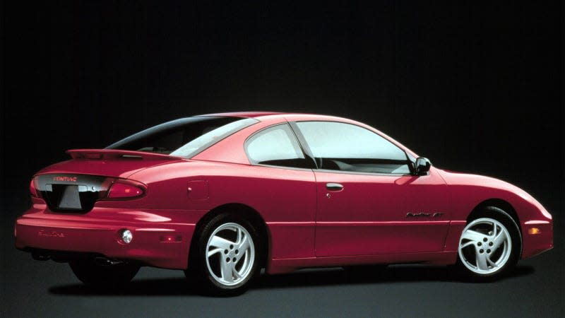 A photo of a red Pontiac Sunfire coupe in a studio. 