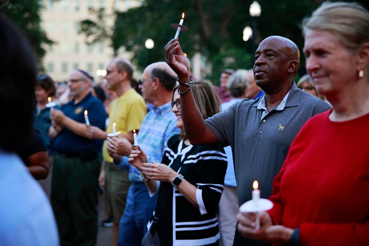 Patrons hold up candles during a vigil Thursday, Nov. 3, 2022 at James Weldon Johnson Park in Jacksonville. People met in solidarity in support of the Jewish community following the recent displays of antisemitic messages on the back of TIAA Bank Field during Saturday's Georgia-Florida game and elsewhere.